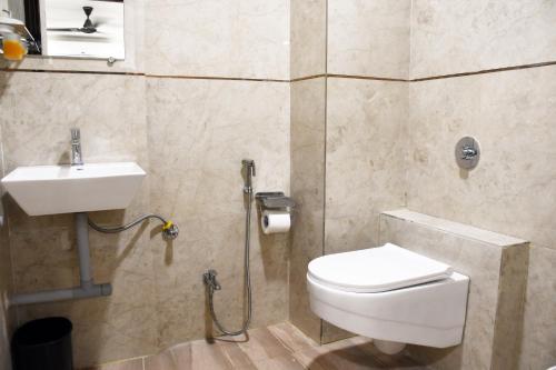 La salle de bains est pourvue de toilettes et d'un lavabo. dans l'établissement Otel, à Nagpur