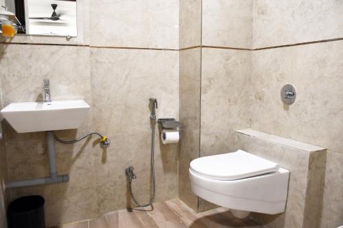 a bathroom with a toilet and a sink at Otel in Nagpur