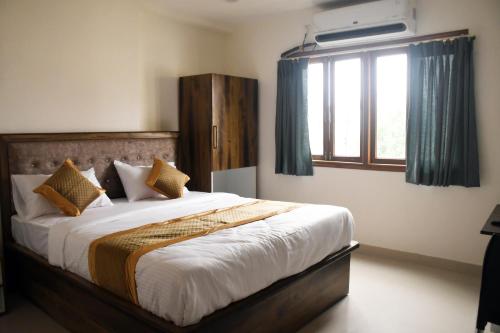 a bedroom with a large bed with a large window at Otel in Nagpur