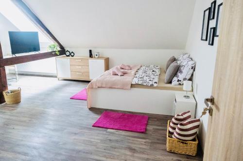 a bedroom with a bed and pink rugs at ŠUMAVSKÝ DVŮR in Sušice