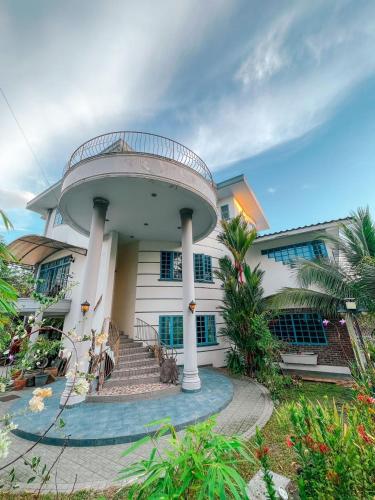 uma grande casa branca com uma escada em espiral em Shangri-La Heights Room em Kota Kinabalu