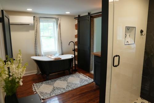 a bathroom with a black tub and a window at The Inn at Terra Farms in Glen Rock