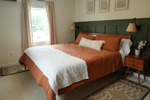 Glen Rock的住宿－The Inn at Terra Farms，一间卧室配有一张带橙色和白色毯子的床