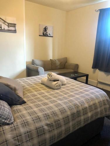 a bedroom with a bed with a blanket and a couch at The Old Station House in Retford
