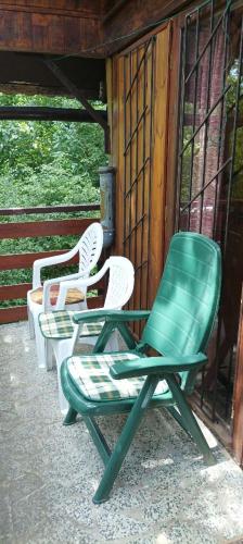 three green and white chairs sitting on a porch at Old cottage, steep hill, read info and rating in Rozdrojovice