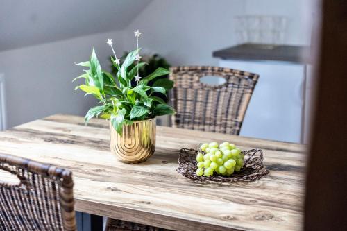 a wooden table with a vase of flowers and grapes at ŠUMAVSKÝ DVŮR in Sušice