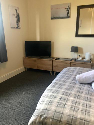 a bedroom with a bed and a flat screen tv at The Old Station House in Retford