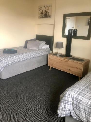 a bedroom with two beds and a mirror and a dresser at The Old Station House in Retford