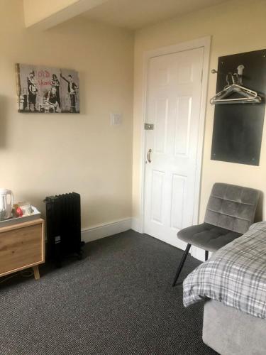 a bedroom with a bed and a chair and a door at The Old Station House in Retford