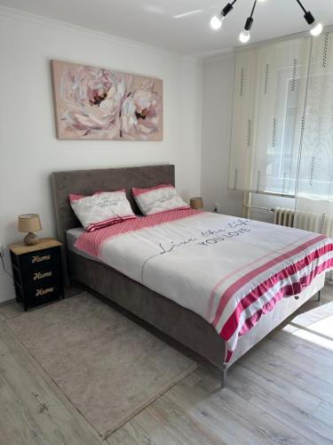 een slaapkamer met een bed met een rode en witte deken bij STUDIO APARTMAN PAVIĆ in Vinkovci