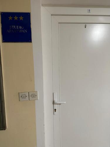 a white door with a blue sign on it at STUDIO APARTMAN PAVIĆ in Vinkovci