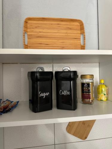 two black containers sitting on a shelf in a kitchen at STUDIO APARTMAN PAVIĆ in Vinkovci