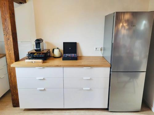 a kitchen with a stainless steel refrigerator and white cabinets at SiOUX stilvoll eingerichtete Apartments im Stadtkern I NETFLIX I NESPRESSO I in Kaufbeuren