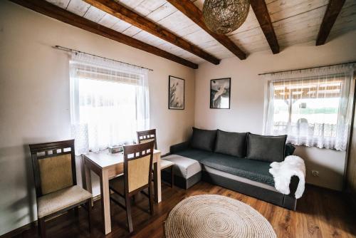 a living room with a couch and a table at Domek na skarpie in Szczybały Giżyckie