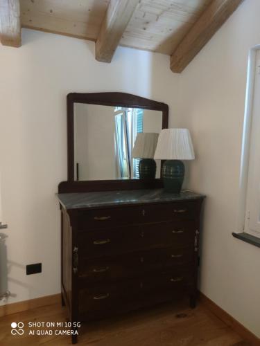 a dresser with a mirror and a lamp on it at La Pezzuola 53 in Sopralacroce
