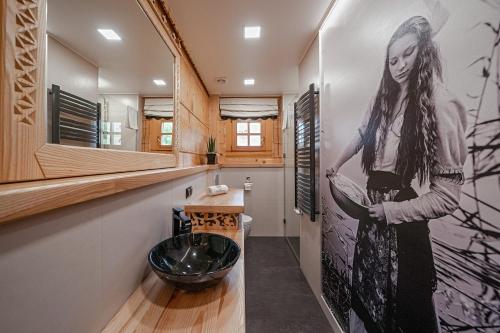 a bathroom with a large painting of a woman on the wall at Rezydencja Pod Sadami in Szczawnica