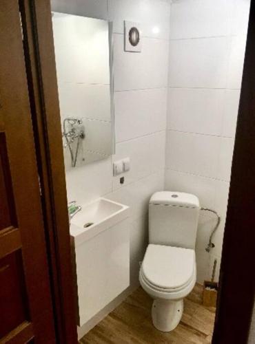 a white bathroom with a toilet and a sink at ArturoDOM Grójecka in Warsaw