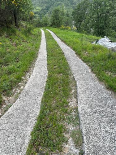 a gravel road in the middle of a field at Chalet sur pilotis avec piscine privée in Lucéram
