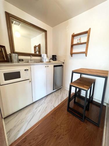a kitchen with a counter and a table and a sink at Carmel Garden Inn in Carmel