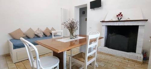 een woonkamer met een tafel en een open haard bij Villa Elvira in Ambra
