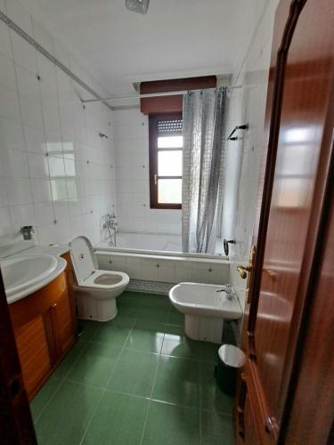 a bathroom with a tub and a toilet and a sink at Casa Chalet, Villa Elisa in Gijón