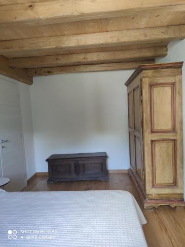 a bedroom with a bed and a wooden cabinet at La Pezzuola 53 in Sopralacroce