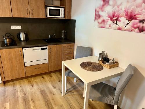 a kitchen with a white table and chairs in a room at EDER- Penzion & Apartmány in Horní Planá