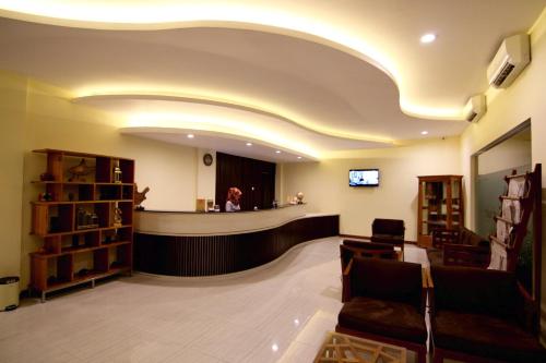una sala d'attesa con un bancone e una donna in uno specchio di Syailendra Hotel Syariah a Jepara