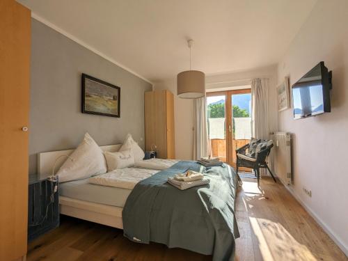 Un dormitorio con una cama y un televisor y una ventana. en Lieblingsort, en Unterwossen