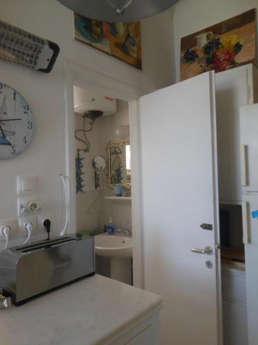 una cocina con fregadero y un reloj en la pared en Mansion at Chora in Andros, en Ándros