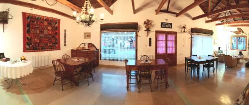 una sala da pranzo con tavoli, sedie e lampadario a braccio di Las Tejuelas Hosteria Patagonica a El Bolsón
