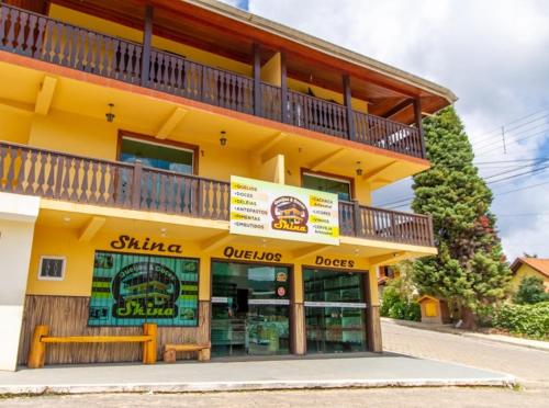 ein gelbes Gebäude mit Balkon darüber in der Unterkunft Pousada serrano in Monte Verde