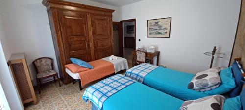 ティラーノにあるRetica Tiranoのベッド2台と椅子が備わる小さな客室です。