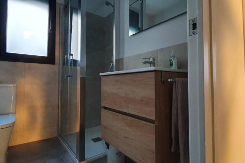 y baño con ducha, lavabo y lavamanos. en CASA CENTRO DEL PUEBLO CON PISCINA PRIVADA en Sant Vicenç de Montalt