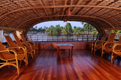 a room with chairs and a table on a boat at Xandari Riverscapes in Alleppey