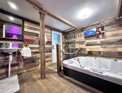 Rustic Rhondda Retreat with Hot Tub & Sauna - Ystrad في Llwyn-y-pia: حمام كبير مع حوض ومغسلة