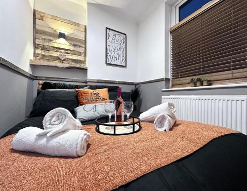 Llwyn-y-pia的住宿－Rustic Rhondda Retreat with Hot Tub & Sauna - Ystrad，一间卧室配有一张带毛巾和桌子的床