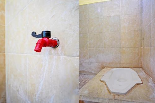 SPOT ON 92730 Lili Kost Syariah في بانيووانجى: مرحاض في حمام به صنبور رد