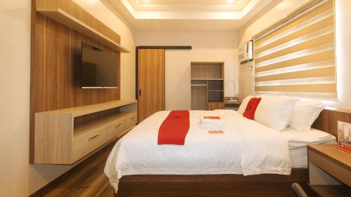 a bedroom with a bed with a flat screen tv at RedDoorz Plus @ Bez Tower and Residences San Juan in Manila