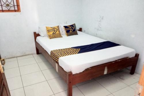 um pequeno quarto com uma cama num quarto em SPOT ON 92743 Kost Elisabeth Syariah em Ngadipuro