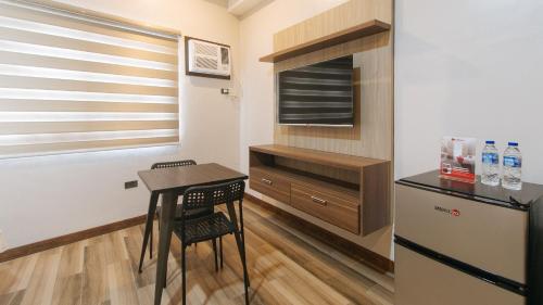a small kitchen with a table and a refrigerator at RedDoorz Plus @ Bez Tower and Residences San Juan in Manila