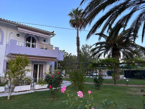 a white house with palm trees and a yard at 7Syn7 in Oreoí