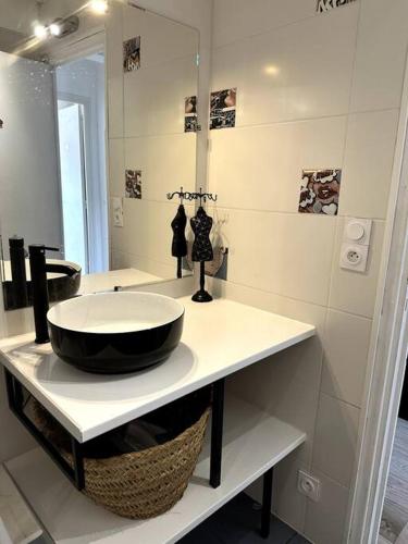 une salle de bain avec un lavabo et un miroir dans l'établissement Appartement Cosy Calao - Parking fermé gratuit, à Perpignan