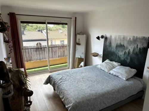une chambre avec un lit et une grande fenêtre dans l'établissement Appartement Cosy Calao - Parking fermé gratuit, à Perpignan
