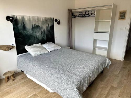 a bedroom with a bed and a painting on the wall at Appartement Cosy Calao - Parking fermé gratuit in Perpignan