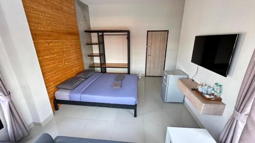 um pequeno quarto com uma cama e uma televisão em Buathong Pool Villa em Ban Khung Taphao