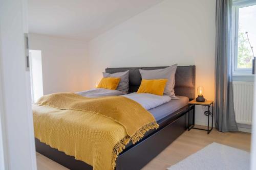una cama con almohadas amarillas en una habitación en Studio Zwei, en Oersberg