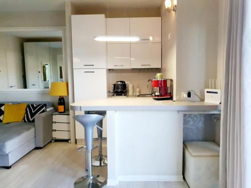 a kitchen with white cabinets and a counter in a room at Appartamento via Riccardo Lombardi 29 in Olbia