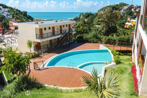 an apartment with a swimming pool and a view of the ocean at Casa Amerigo in Morro de São Paulo