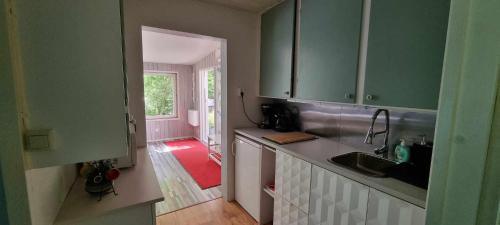 a kitchen with green cabinets and a sink at Lygnareds Camping in Alingsås